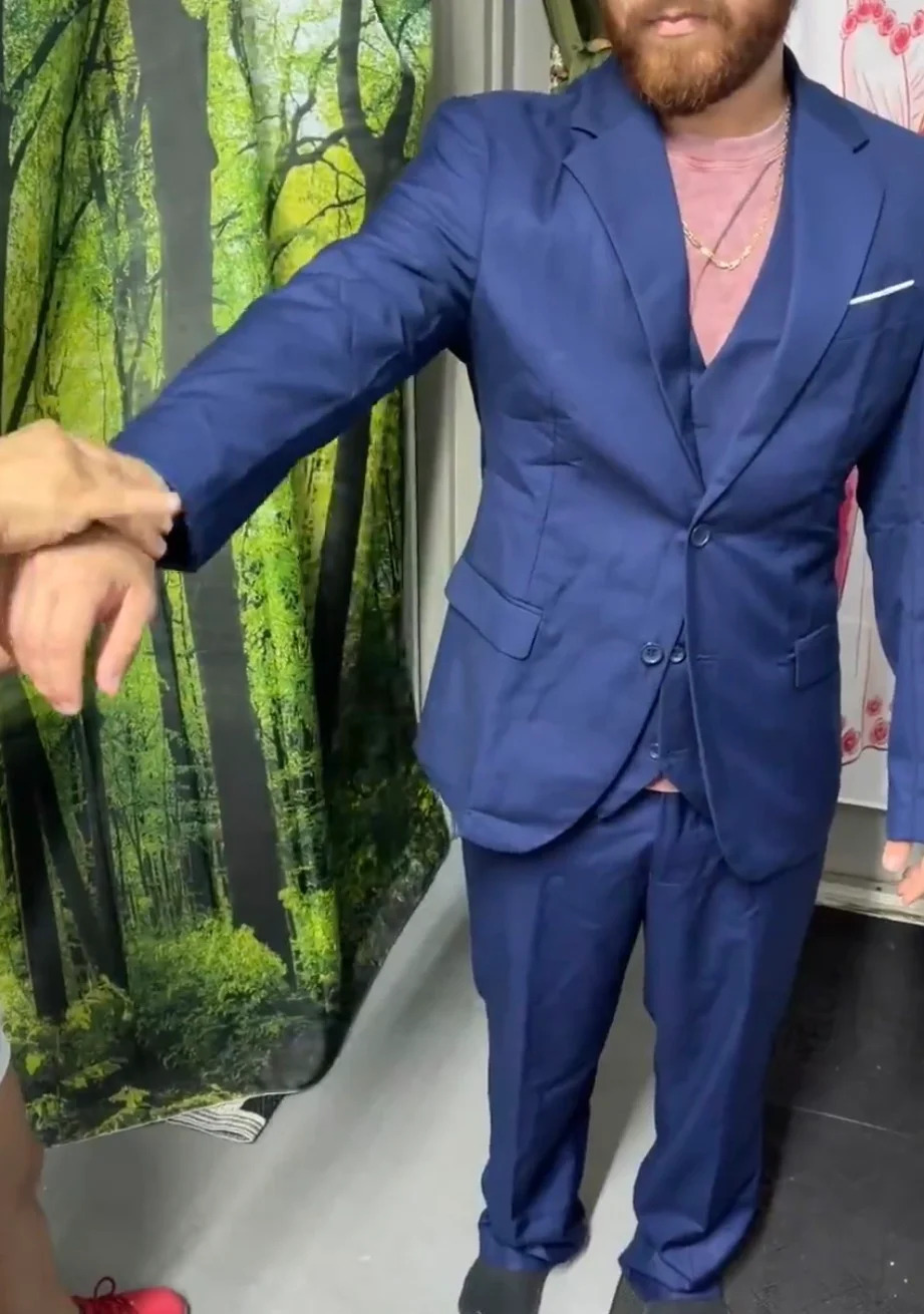 Sleeve length check on a navy three-piece suit